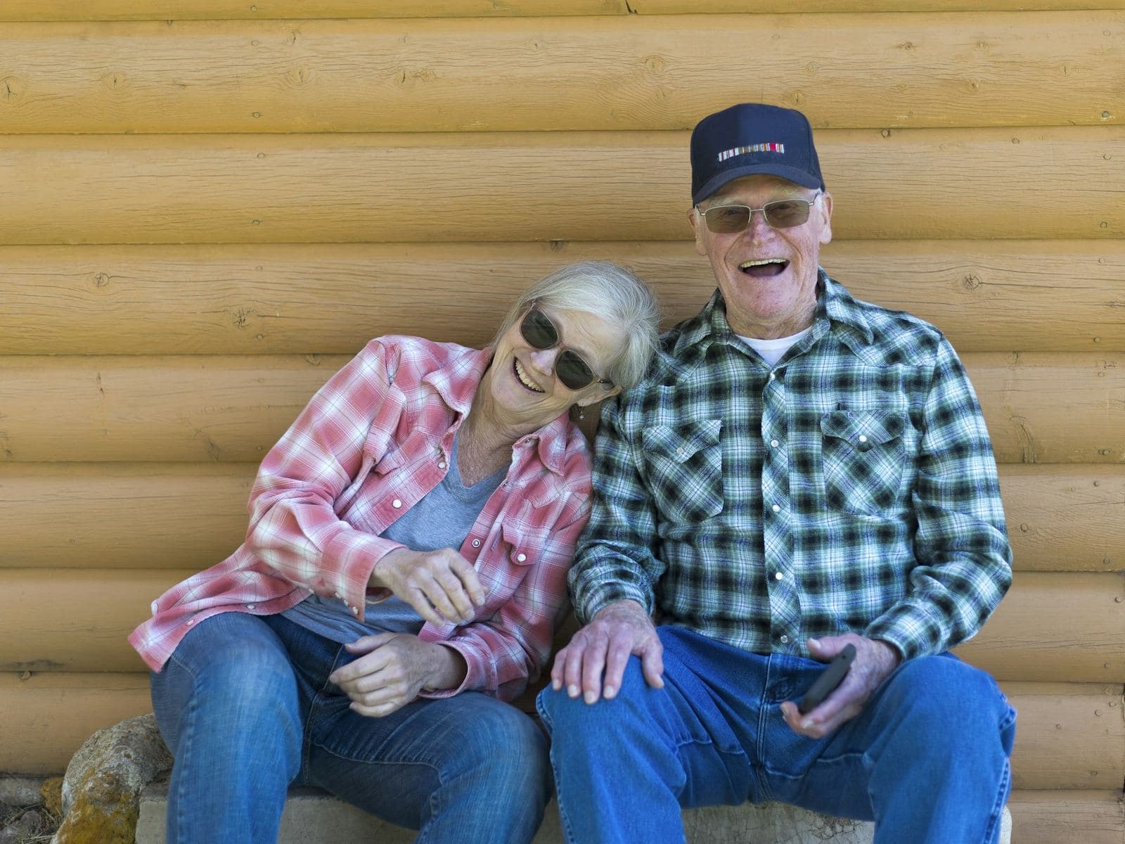 Couple d'aînés riant sur la galerie d'un chalet
